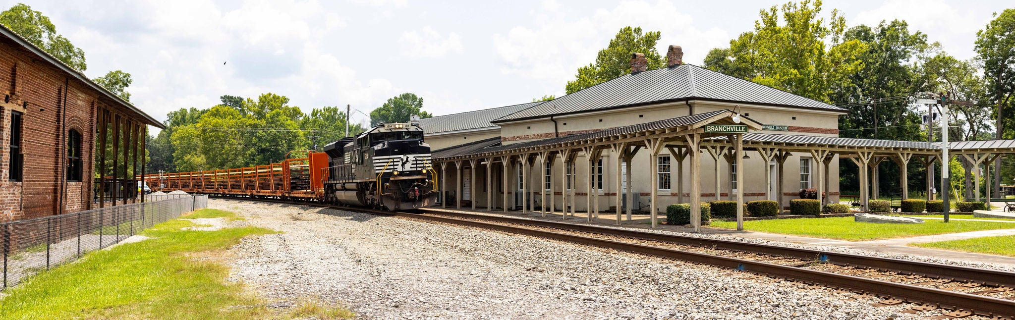 Norfolk Southern employee who uses safety technology in safety vest and hat smiling